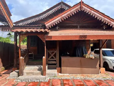 a house with a porch with a car parked in front at Homestay Jasmin in Taiping