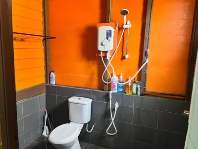 a bathroom with a toilet and a phone on the wall at Homestay Jasmin in Taiping