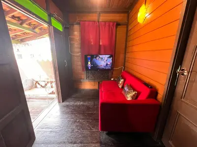 a red couch in a room with a tv at Homestay Jasmin in Taiping