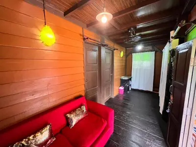 a red couch in a room with a wooden wall at Homestay Jasmin in Taiping