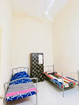 a bedroom with two beds and a mirror at No 115 Homestay Tasik Raban Lenggong in Kampong Kuala Chegar
