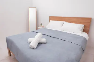 a large bed with two white towels on it at Taiping Homestay 5R3B, 9mins - Zoo & Lake Garden Taiping in Taiping