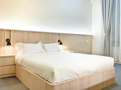a bedroom with a large bed and two lamps at Milan Backpacker Hostel in George Town