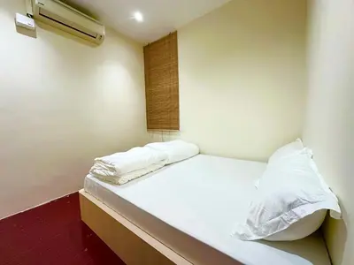 a room with a bed with white sheets and a window at Milan Backpacker Hostel in George Town