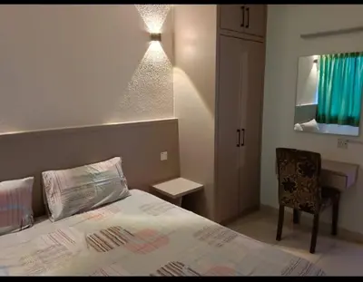 a bedroom with a bed and a chair and a desk at Seri Sayang 2 Bedrooms Seaview Resort in Batu Ferringhi