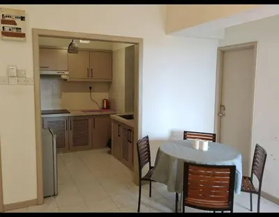 a kitchen with a table and chairs in a room at Seri Sayang 2 Bedrooms Seaview Resort in Batu Ferringhi