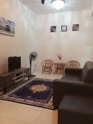 a living room with a couch and a table at Lily Impiana Homestay in Baling