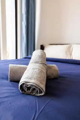 a towel laying on top of a bed at Beacon Suites #Georgetown #Rooftop Pool #20 #Cozy in George Town