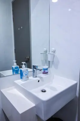 a bathroom with a white sink and a mirror at Beacon Suites #Georgetown #Rooftop Pool #20 #Cozy in George Town
