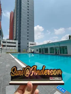 a hand holding a sign in front of a swimming pool at Suri Homestay Anderson Ipoh in Ipoh