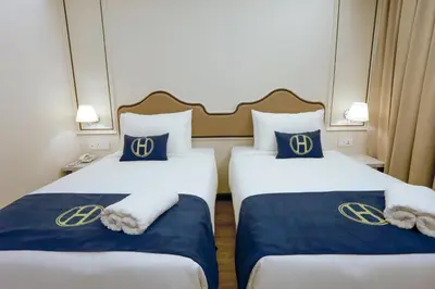 two beds in a hotel room with the houston at The Host Hotel in Ipoh