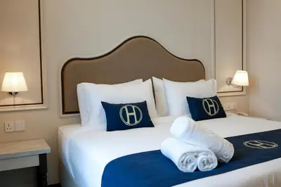 a hotel room with a bed with blue and white pillows at The Host Hotel in Ipoh