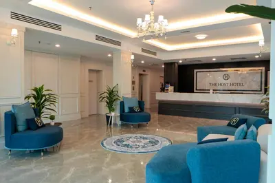 a hotel lobby with blue chairs and a television at The Host Hotel in Ipoh