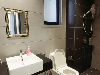 a bathroom with a sink and a toilet and a mirror at relax familystay -Urban suites-3BR-10pax in Jelutong