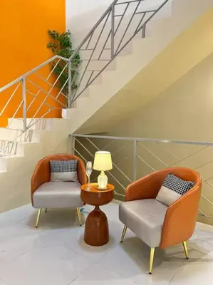 two chairs and a table in a room with stairs at Happiness Stay 20pax Karaoke & Snooker in Ipoh