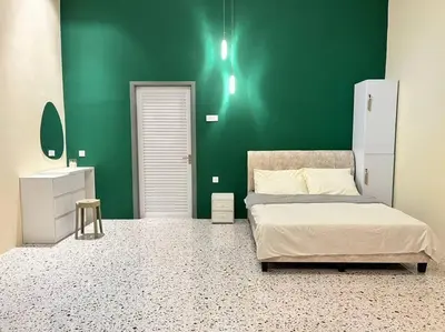 a green bedroom with a bed and a green wall at Happiness Stay 20pax Karaoke & Snooker in Ipoh