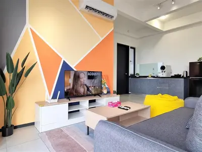 a living room with a couch and a tv at Sunlit Minimalist Suite, 7 Pax at Urban Suites Georgetown by SuperStay in Jelutong