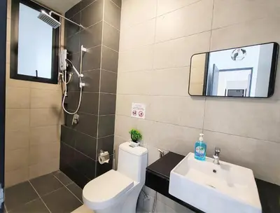 a bathroom with a toilet and a sink and a mirror at Sunlit Minimalist Suite, 7 Pax at Urban Suites Georgetown by SuperStay in Jelutong