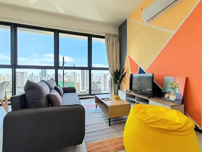 a living room with a couch and a tv at Sunlit Minimalist Suite, 7 Pax at Urban Suites Georgetown by SuperStay in Jelutong