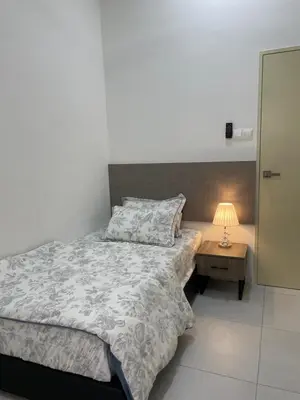 a bedroom with a bed and a table with a lamp at The Imans Place in Kepala Batas