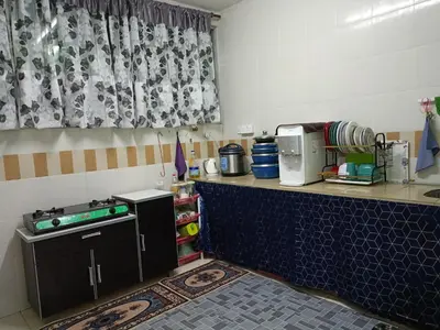 a kitchen with a counter top with a microwave at Seri Raban Homestay in Kampong Kuala Chegar