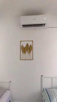 a white wall with a picture of three gold hearts at Bilik Umairah in Gerik