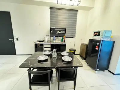 a kitchen with a black table with chairs and a refrigerator at World Class Apartment In Georgetown 3BR in Jelutong