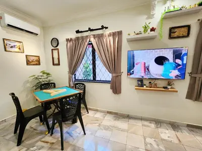 a dining room with a table and a tv at IPOH Rainbow Blissful Villa, Persiaran Halaman Ampang Ipoh in Ipoh