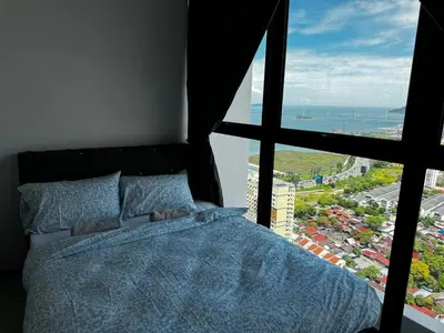 a bedroom with a bed and a view of the ocean at Familystay Home 3BR-10PAX in Gua Sai