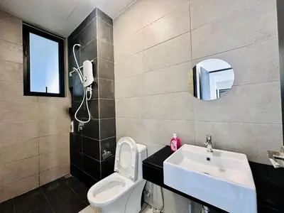 a bathroom with a sink and a toilet and a mirror at Familystay Home 3BR-10PAX in Gua Sai