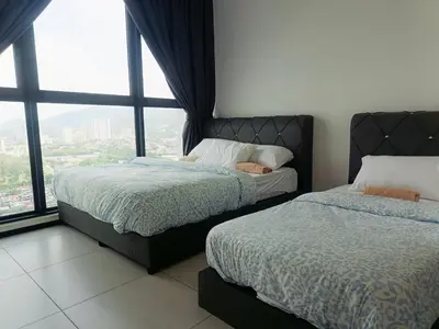a bedroom with two beds and a large window at Familystay Home 3BR-10PAX in Gua Sai