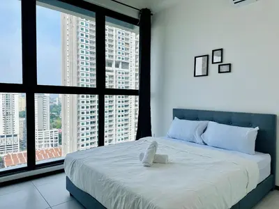 a bedroom with a large bed with large windows at Familystay Home 3BR-10PAX in Gua Sai