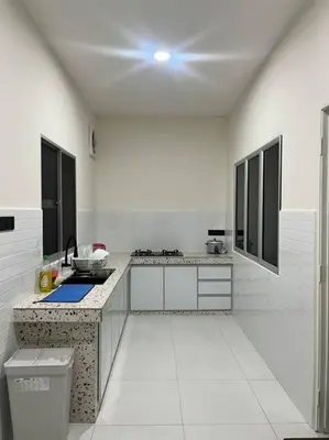 a white kitchen with a sink and a counter at Homestay Taman Banjar Indah, Teluk Intan in Teluk Intan