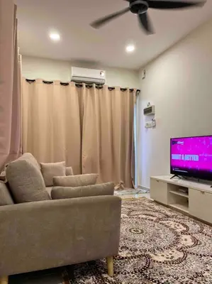 a living room with a couch and a flat screen tv at Homestay Taman Banjar Indah, Teluk Intan in Teluk Intan