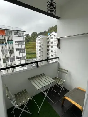 a balcony with two chairs and a bench on a building at AYAAN Comfy Homestay with FREE WiFi in Tanah Rata