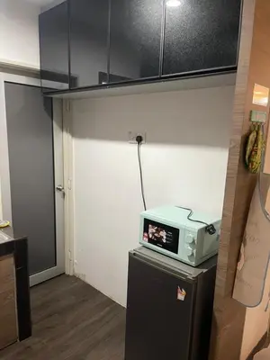 a microwave sitting on top of a refrigerator in a kitchen at AYAAN Comfy Homestay with FREE WiFi in Tanah Rata