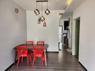 a dining room with a table and four red chairs at AYAAN Comfy Homestay with FREE WiFi in Tanah Rata