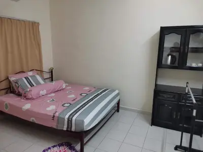 a bedroom with a bed with pink sheets and a dresser at Taman Medan Seri Sentosa, Ayer Tawar in Ayer Tawar