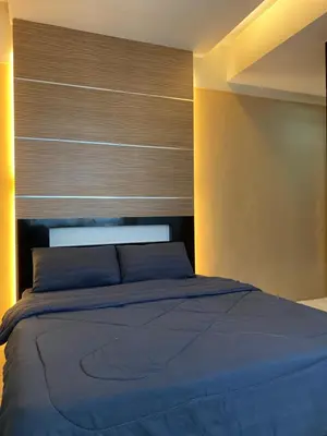 a bedroom with a blue bed with a wooden headboard at Qaseh Homestay Cameron Highlands 5 in Brinchang