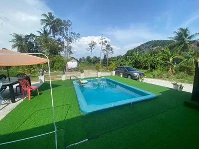 a swimming pool in a yard with a table and a car at Maison Helysa Homestay in Lumut