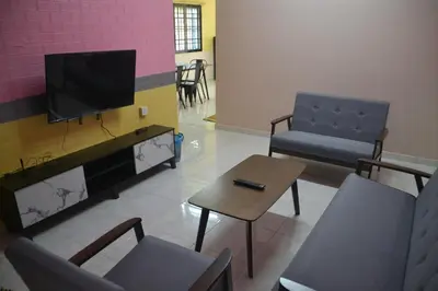 a waiting room with a tv and chairs and a table at Yim's Homestay in Kuala Kubu Baharu