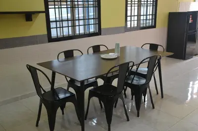 a wooden table with black chairs in a room at Yim's Homestay in Kuala Kubu Baharu