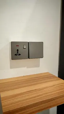 a lightswitch on a wall next to a wooden table at 23 Inn Queenbed Standard Room in Bukit Mertajam