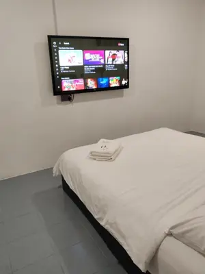 a bedroom with a bed with a flat screen tv on the wall at 23 Inn Queenbed Standard Room in Bukit Mertajam