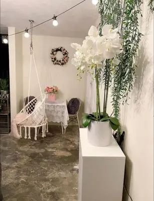 a room with a swing and a table with white flowers at Cottage Near Lake Garden in Taiping