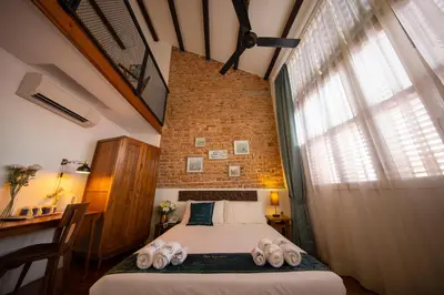 a bedroom with a bed and a brick wall at Sweet Cili Boutique Hotel in George Town
