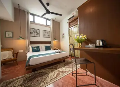 a bedroom with a bed and a table and a chair at Sweet Cili Boutique Hotel in George Town