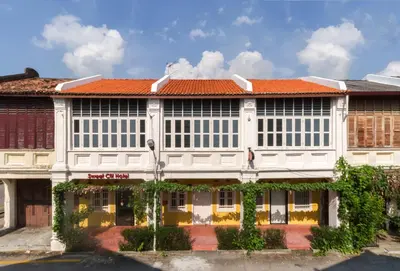 a white building with an orange roof at Sweet Cili Boutique Hotel in George Town