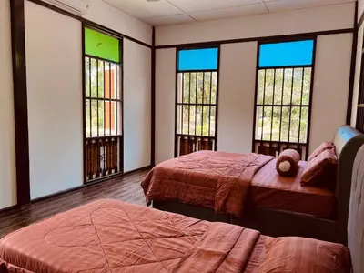 a room with two beds and three windows at Inap Desa R'Sawit Pintu A in Sekincan
