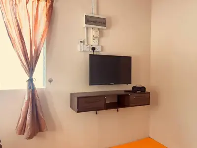 a flat screen tv on a wall in a room at Inap Desa R'Sawit Pintu A in Sekincan